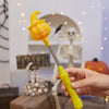 Une main tient une lanterne d'Halloween jaune lumineuse en forme de chapeau de sorcière et de chaudron qui dégouline.