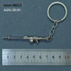 A silver miniature MG3 alloy gun model keychain with a metal ring attached, shown next to a ruler.