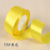 A roll of bright yellow silk satin ribbon used for gift wrapping and craft projects.