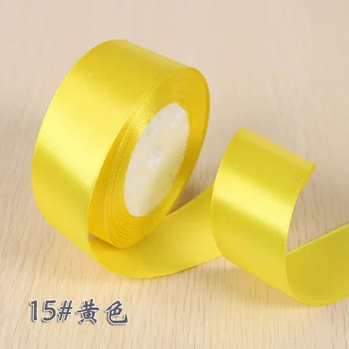A roll of bright yellow silk satin ribbon used for gift wrapping and craft projects.