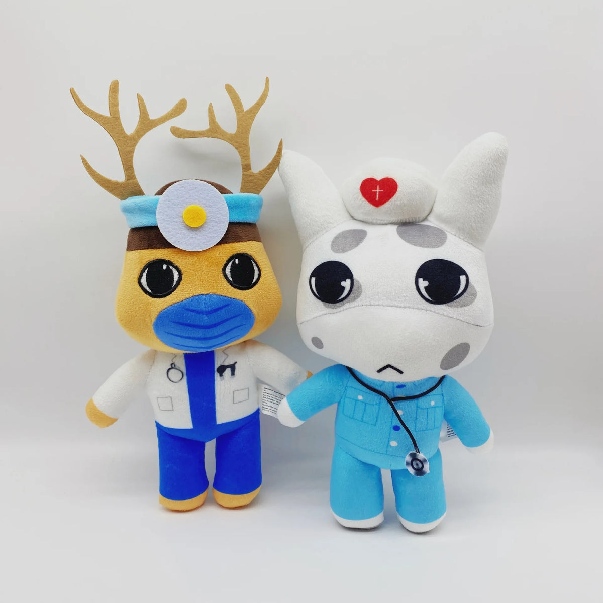 A plush toy of a dog with deer antlers and a blue hospital outfit.