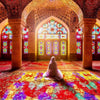 Islamic mosque interior with an arched dome and stained glass windows, featuring vibrant red and gold patterns on the floor.