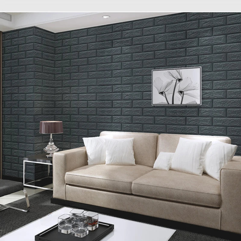 A beige sofa is placed in front of a dark gray brick wall panel featuring a minimalist floral artwork.