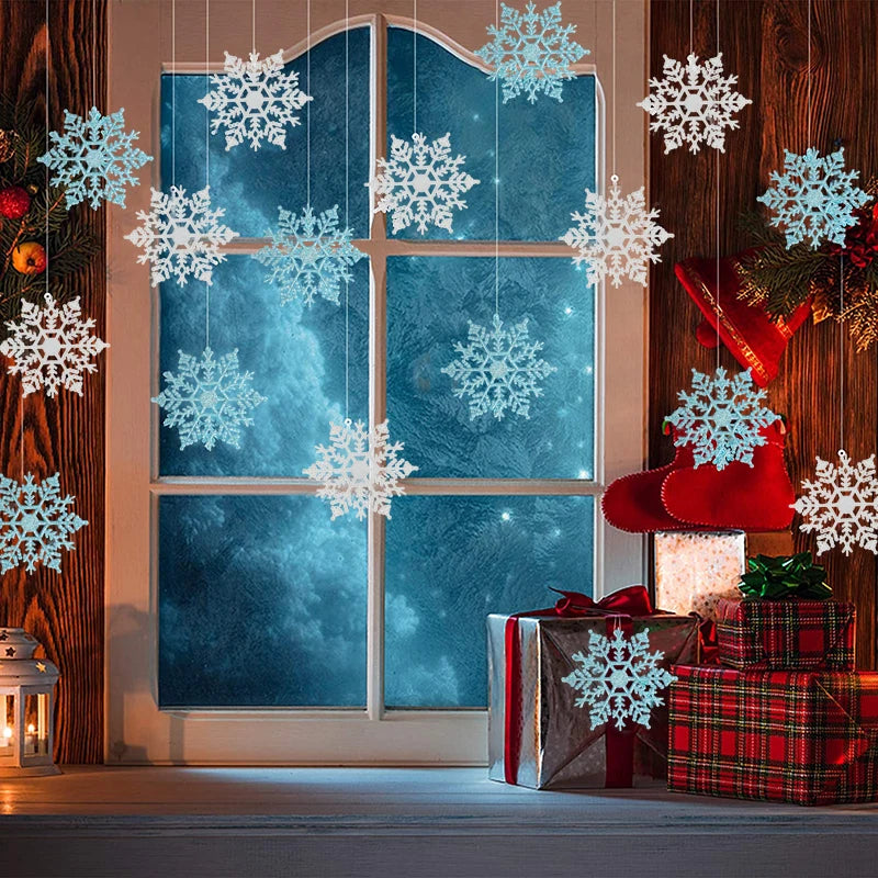 A window decorated with white snowflake cutouts and red Christmas stockings, featuring a gift box.