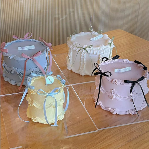 A set of three decorative cake toppers featuring pink and cream frosting with bowknot ribbons.