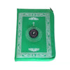 A green portable travel prayer mat with an ornate border and a compass design.