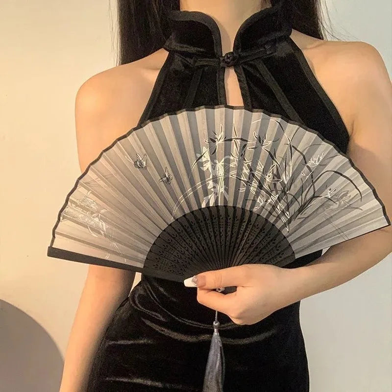 A black velvet top features a large gray bamboo folding hand fan with intricate detailing.