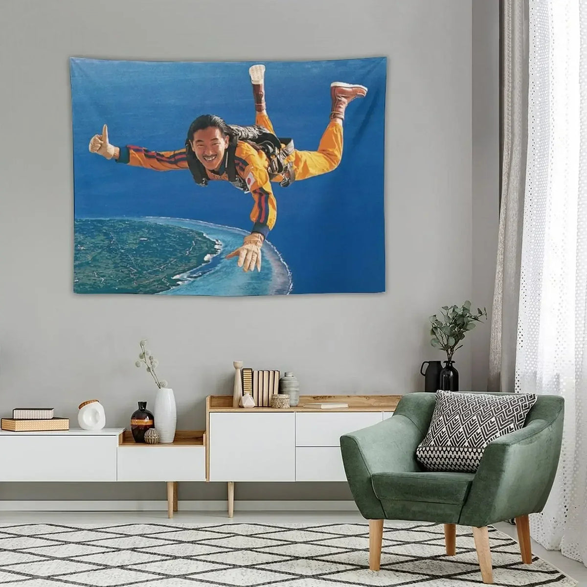A blue wall tapestry featuring a man with long dark hair and orange clothing celebrating with his arms raised against a blue 