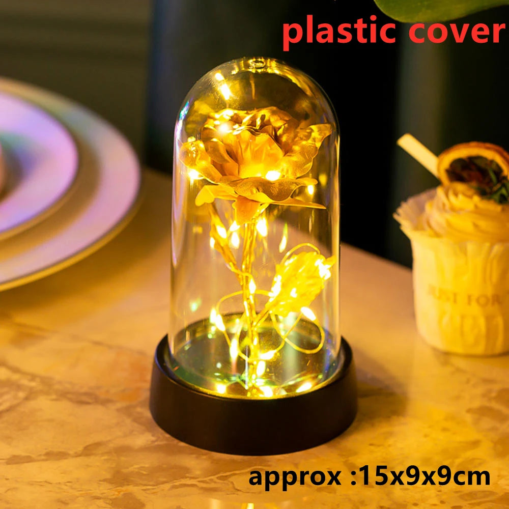 A glass dome containing an LED galaxy rose artificial flower displayed on a dark base.