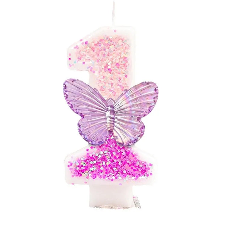 A birthday candle decorated with pink glitter and a purple butterfly shape.