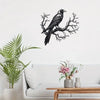 Black raven perched on a bare tree branch metal wall art displayed above a white sofa.