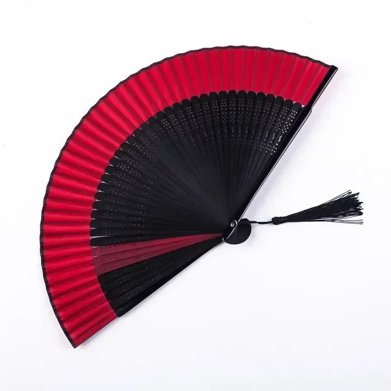 A red and black traditional Chinese folding fan with pleated paper blades.