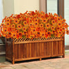 A wooden planter filled with bright orange and yellow artificial autumn flowers.
