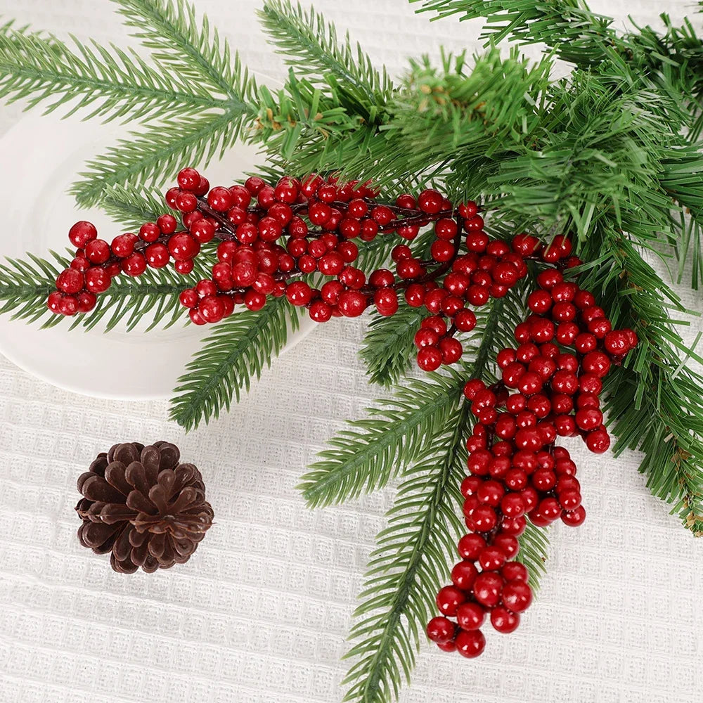 A branch of artificial red holly berries and green pine needles used for Christmas decoration.