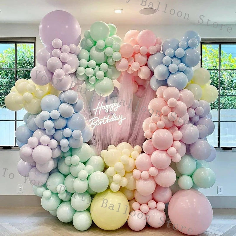 A large balloon garland featuring pink, purple, and light green balloons used for decoration.