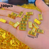 A hand holds 100 pieces of gold-colored metal prosperity decorations, measuring 6mm x 0.2in.