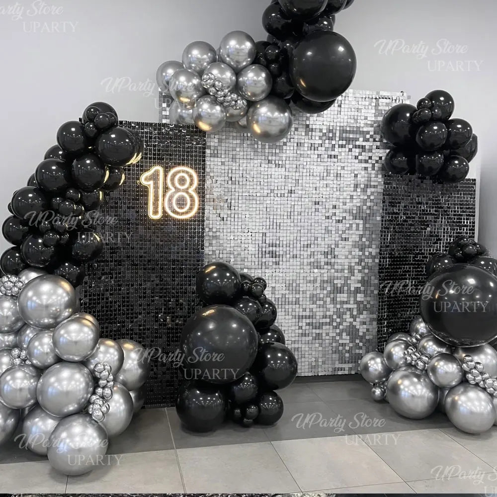 Fond mural pailleté noir et argent avec des ballons ronds et le chiffre 18.