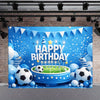 A blue birthday backdrop featuring soccer balls, balloons, and confetti against a brick wall.