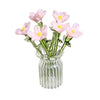 A bouquet of pink and yellow hand-blown glass flowers in a clear glass vase.