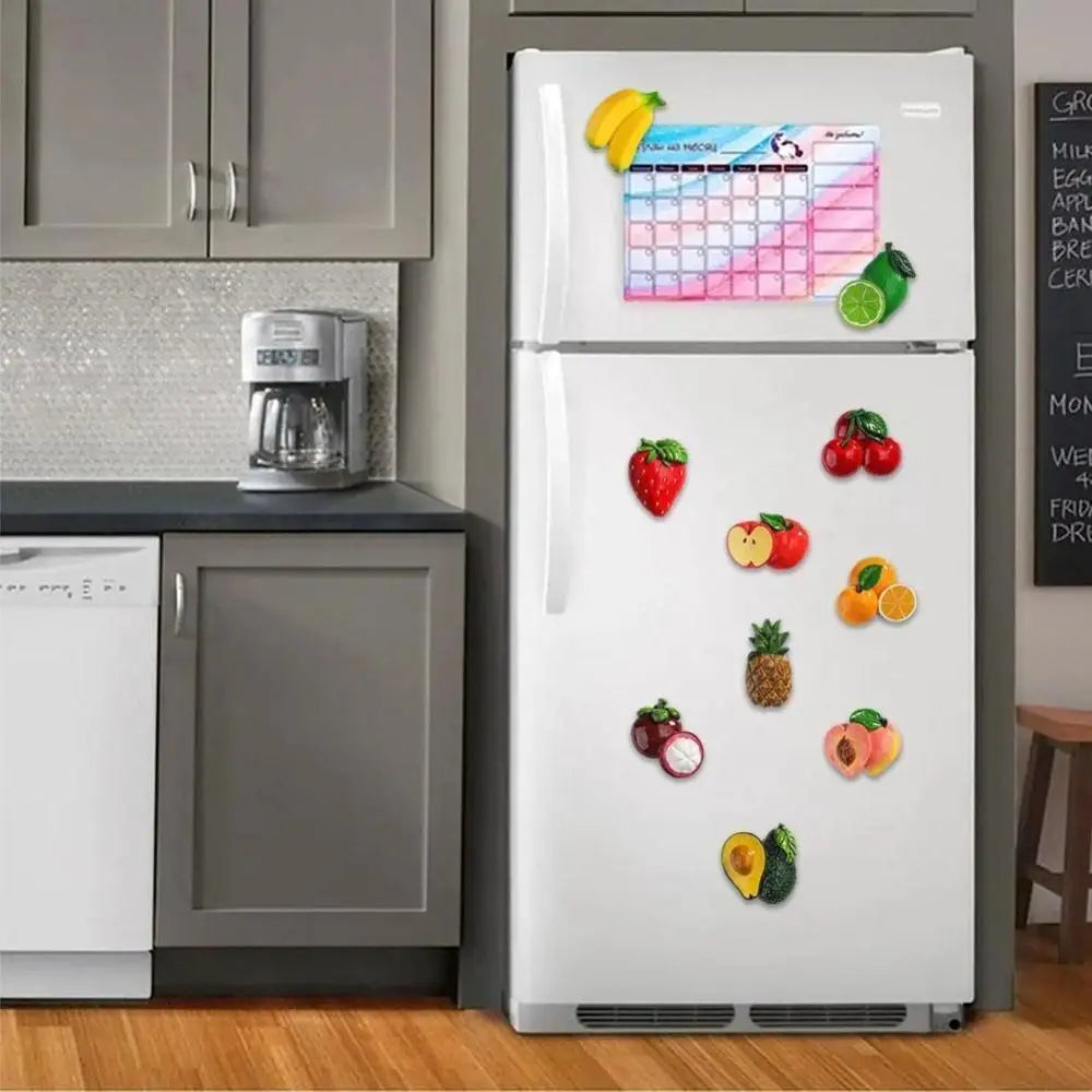 A refrigerator door displaying various fruit and vegetable magnets on a white background.