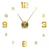 A modern 3D acrylic wall clock face with gold-colored numbers and hands displaying the time.