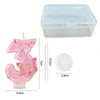 Pink glitter butterfly number candle set with a clear plastic container and a white disc.