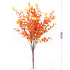 Artificial daisy bouquet with orange and yellow flowers on a thin stem displayed in a glass vase.
