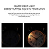 A vintage twin-bell alarm clock with a warm night light illuminating the dial.