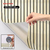 Close-up of faux wood grain self-adhesive wallpaper showing a section with vertical stripes and a hand measuring thickness.