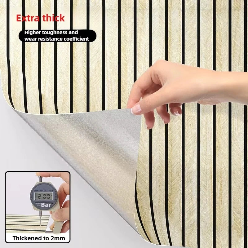 Close-up of faux wood grain self-adhesive wallpaper showing a section with vertical stripes and a hand measuring thickness.