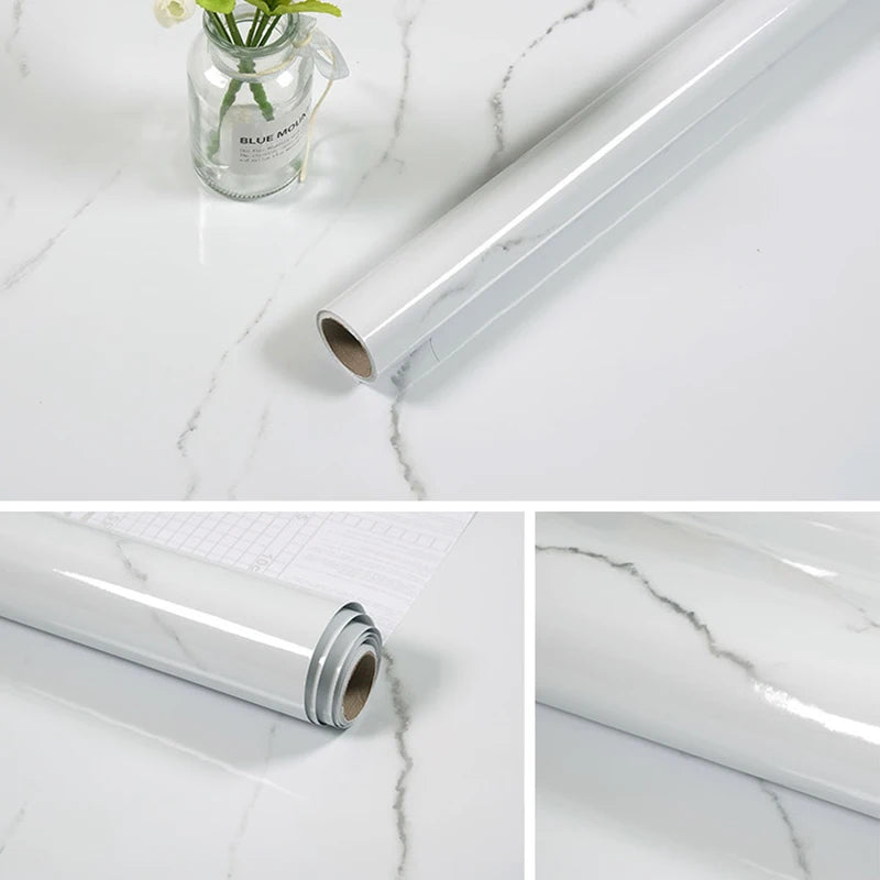 Roll of white marble contact paper lying on a white marble surface next to a glass vase.