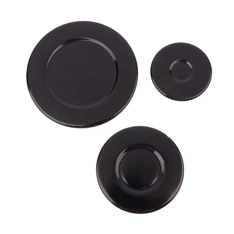 A set of black gas stove burner caps for efficient cooking.