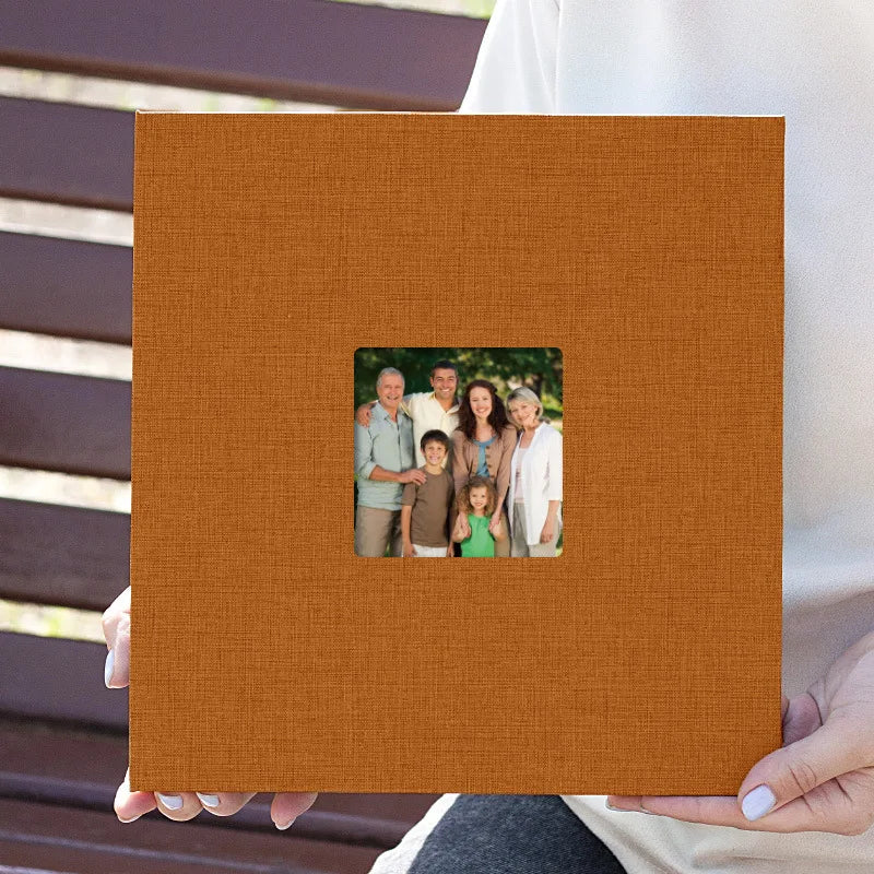 A brown linen scrapbook with a square opening displaying a photo of a multi-generational family.