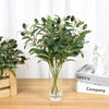 Artificial olive leaf branch with dark green leaves and small black olives in a clear glass vase