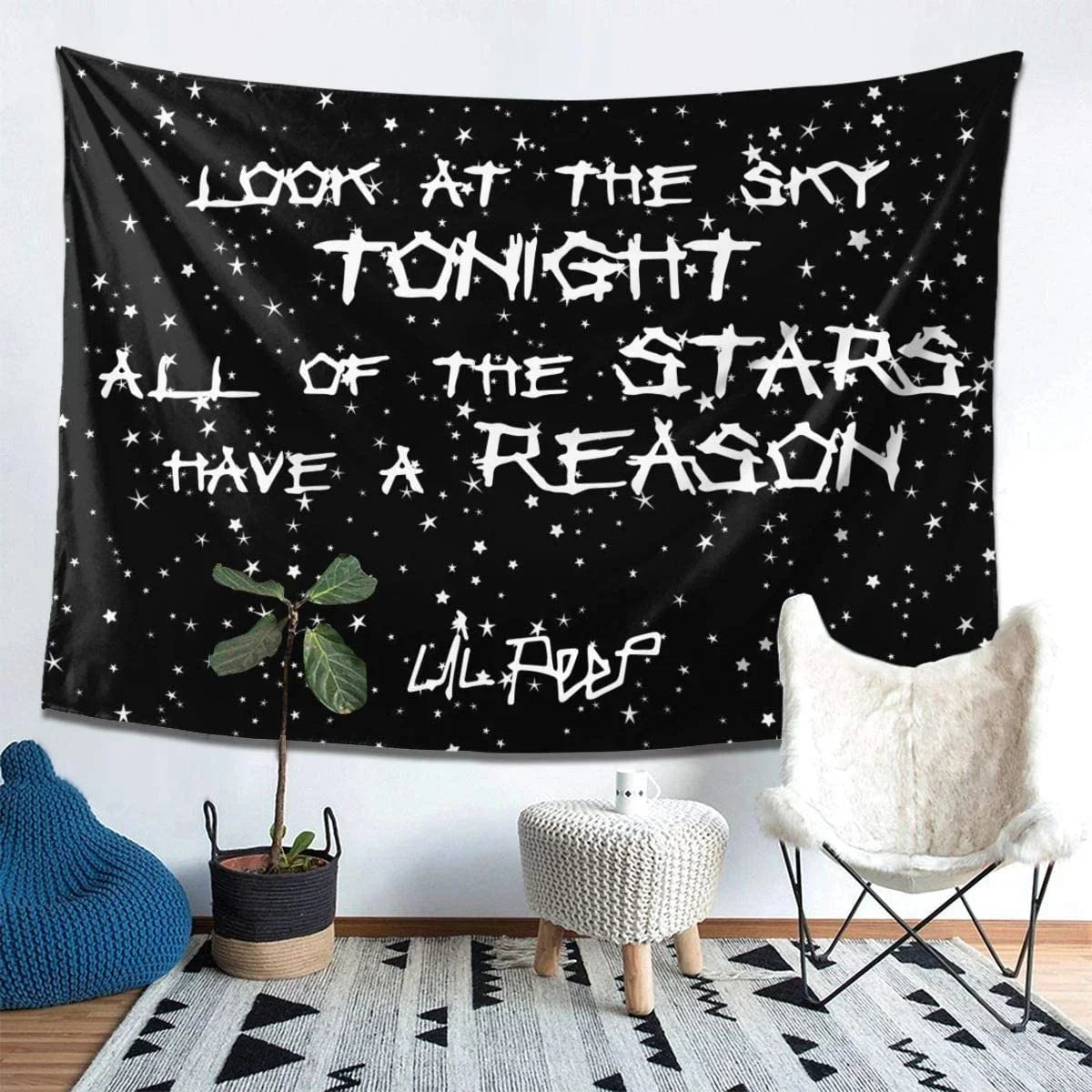 A black tapestry wall hanging featuring white text that reads Look at the sky tonight all of the stars have a reason