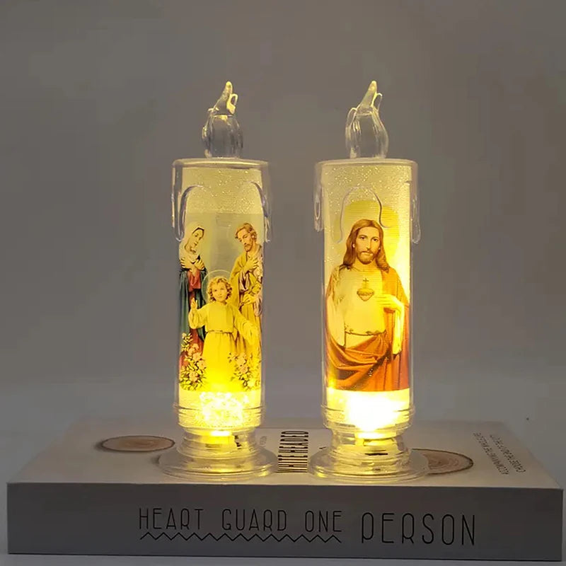 A clear glass flameless LED religious prayer candle with a flame-like light is displayed on a white base.