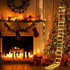 A festive fireplace scene decorated with Christmas lights and Santa Claus elements, including a lighted ladder tree.