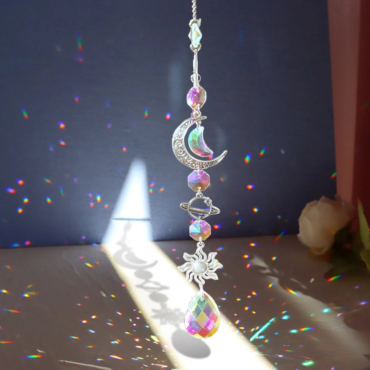 A silver pendant featuring a crescent moon and sun motif with iridescent crystal elements.