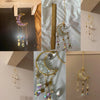 A collection of crystal dreamcatchers and sun catchers featuring moon shapes, stars, and rainbow prisms hanging against a lig
