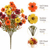 A bouquet of vibrant artificial pansy flowers in shades of orange, yellow, and deep red.