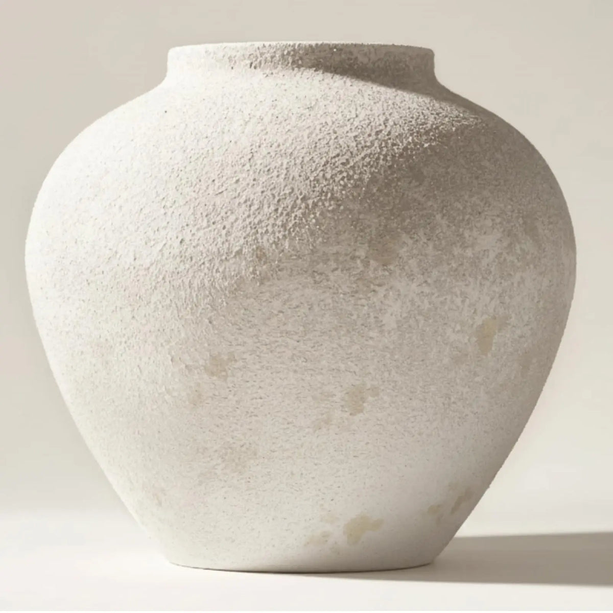 A large matte black decorative vase with a textured, light gray finish is shown from a slight angle.