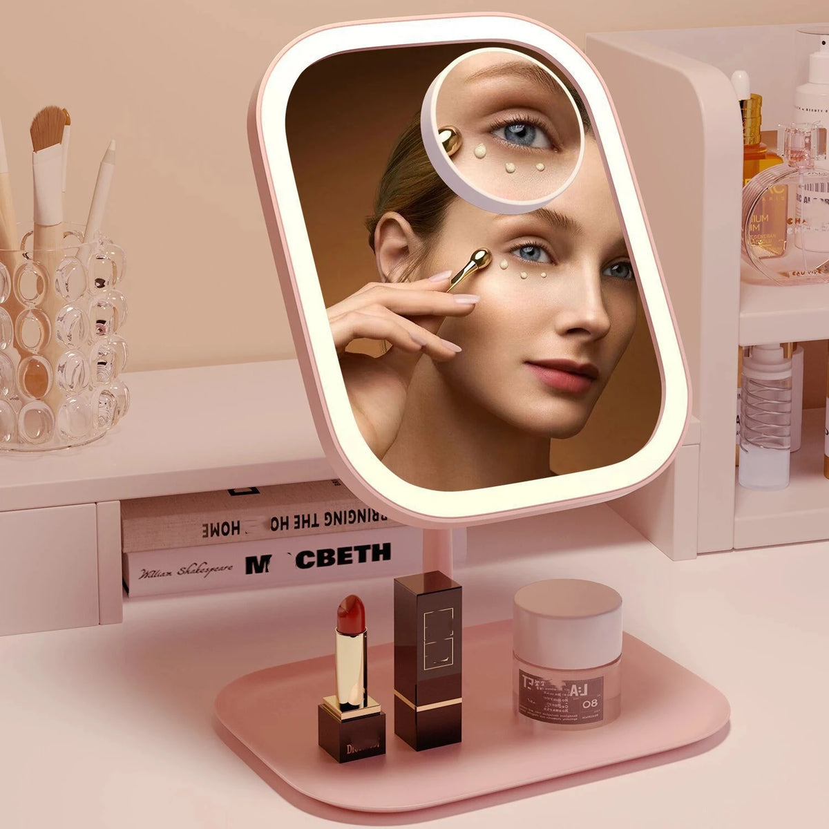 A pink LED touch makeup mirror is shown with a model applying makeup, resting on a pink surface.