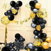 A display of black and gold latex balloons arranged in a heart shape for a birthday celebration.