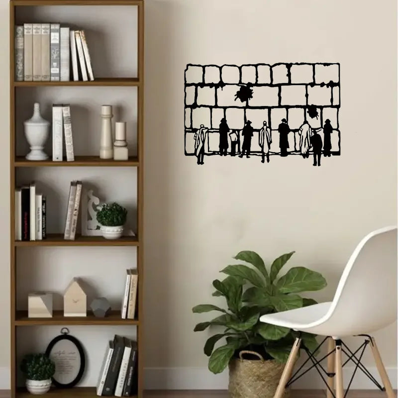 Gerahmte schwarze Metallzaun-Kunst mit Silhouetten von Menschen und Bäumen an einer hellen Wand.