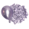 A single metallic lilac latex balloon next to a pile of crumpled silver foil balloons.