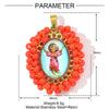 A pendant featuring a small figure of the Virgin Mary in a framed oval surrounded by red beads and attached to a gold-colored