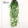 A long, cascading wall hanging of artificial green plant vines in a woven basket.
