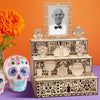 A wooden memory box for Día de los Muertos featuring a photo display and decorative skulls.