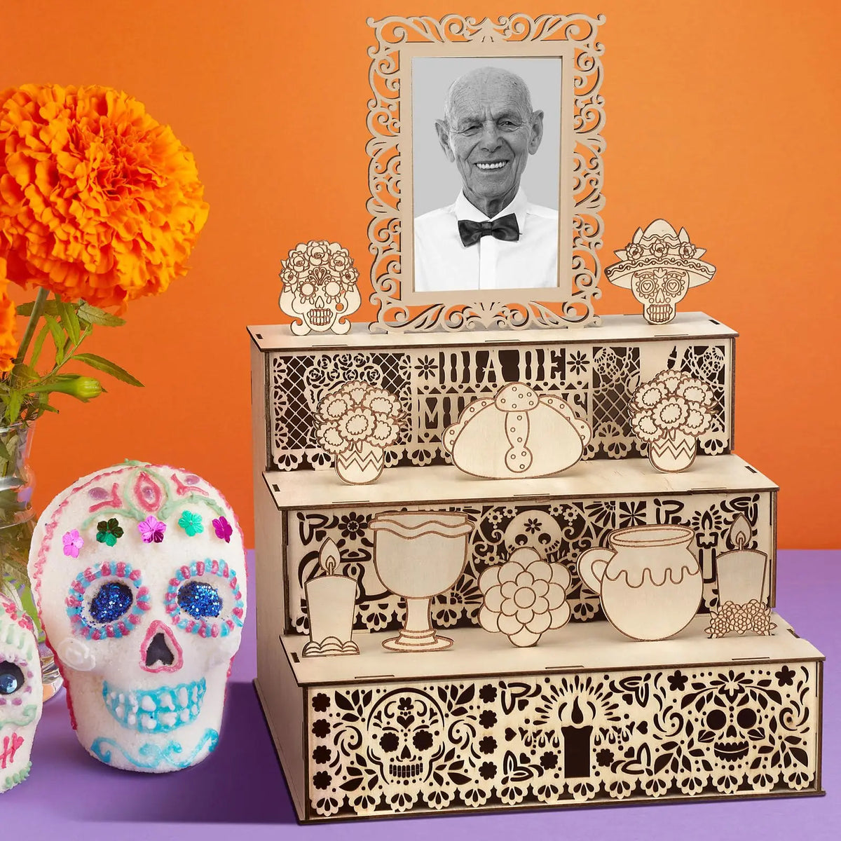 A wooden memory box for Día de los Muertos featuring a photo display and decorative skulls.