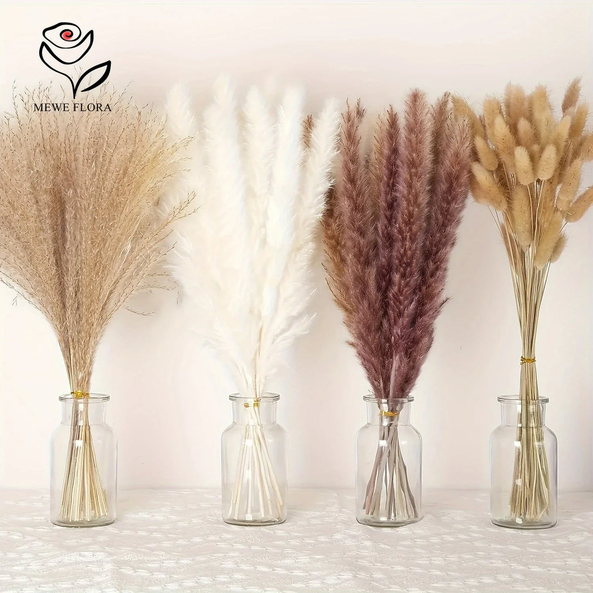 Bouquet de queues de lapin de pampas séchées avec diverses nuances de beige et de brun dans des vases en verre